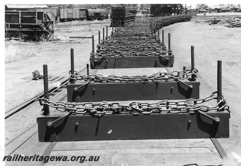 P20569
Rake of newly constructed timber wagons with chains, grounded van body in background, Midland Workshops, ER line, view looking over and along the rake, c1955
