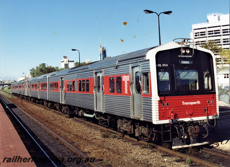 P20686
Transperth ADL class 809 railcar with the black and red livery on the front heading a four car railcar set heading towards Fremantle, West Perth, view along the train (see also P21302)
