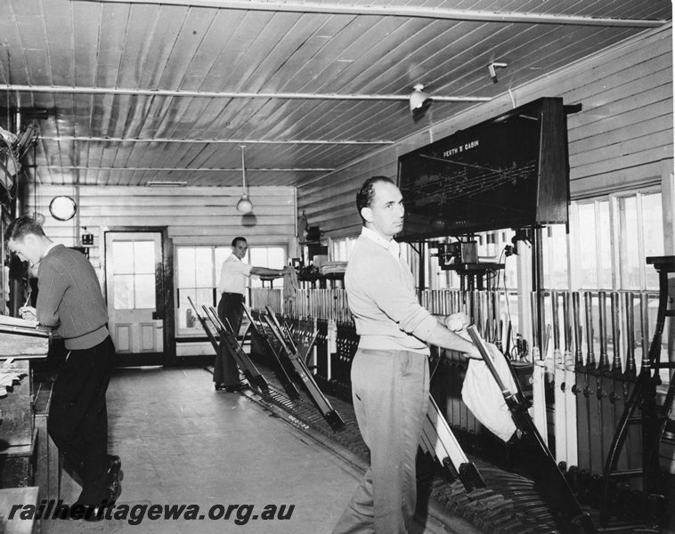 P20691
Interior view of signal box Perth B cabin, frame, levers, track diagram, three signalmen on duty 
