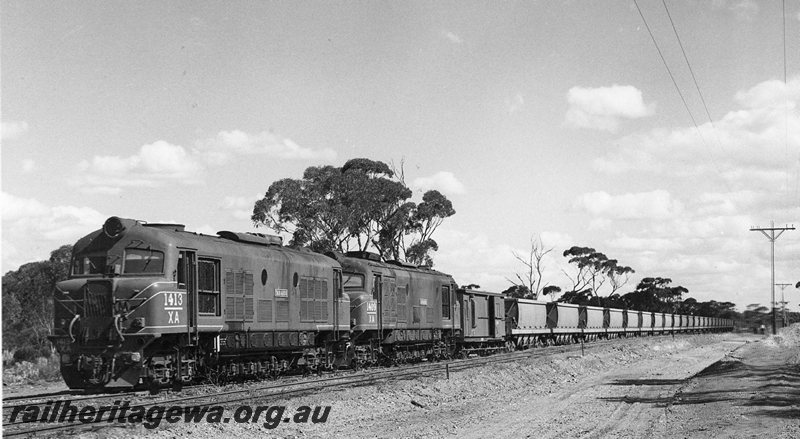 P20727
XA class 1413 & XA class 1409  (both locomotives fitted with air brakes) hauls empty salt train (XNG wagons) through Widgiemooltha.  Livery of both locomotives green with red/yellow stripe. CE line. 
