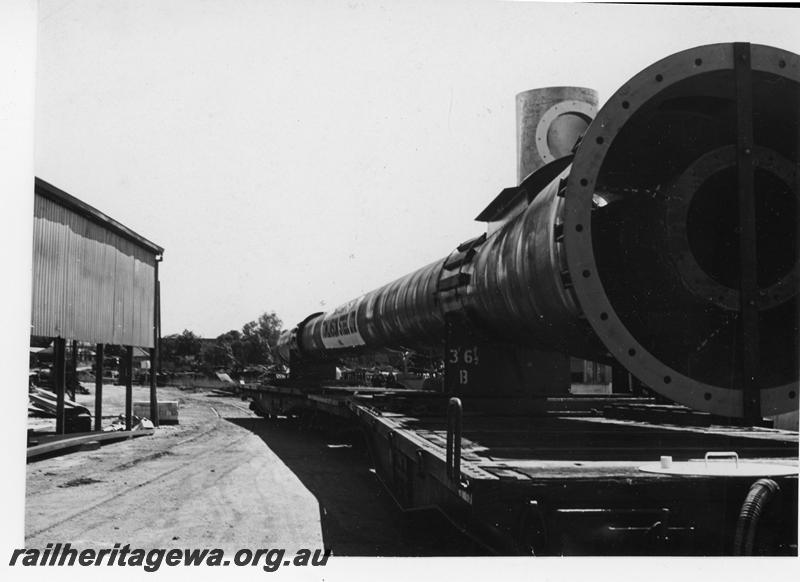 P21088
Rake of flat wagons, loaded with long Tomlinson steel chimney, shed, siding, Welshpool, SWR line, trackside view
