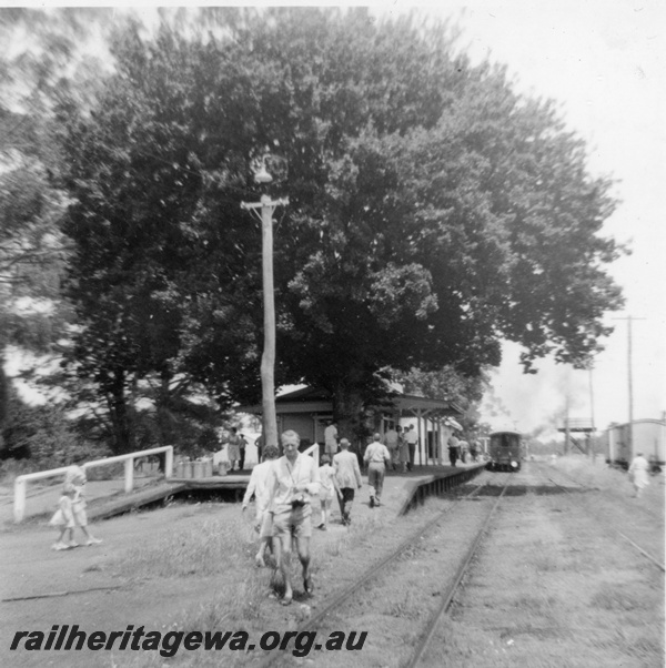 P21156
Station building, cart dock, oak tree, yard light, Boyanup, PP line, large number of people on the platform, view along the track
