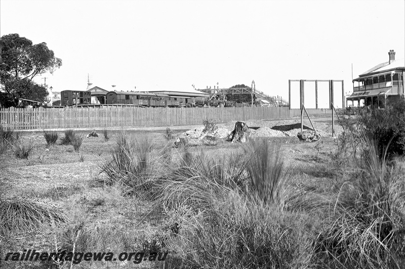 P21200
Station building, footbridge, Bayswater, wagons at the platform, hotel in the view
