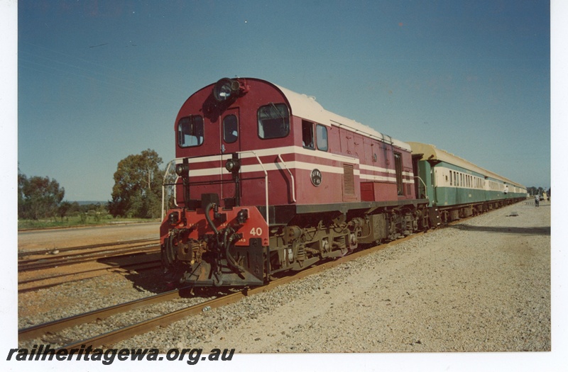 P21208
Ex MRWA F class 40, in maroon livery with white stripes, on train of ex WAGR green and cream passenger carriages, front and side view, c1980s-90s
