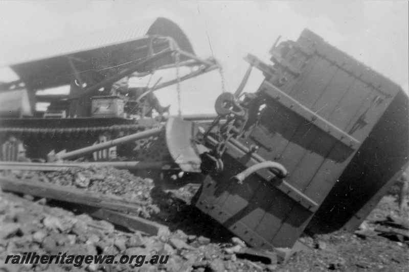 P21217
Derailment on Wiluna line 2 of 7, wagon on side, manganese ore spilled from the wagons,, corrugated iron, NR line, trackside view
