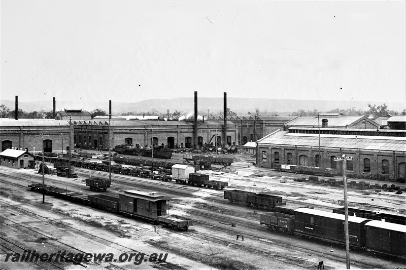 P21256
View of Midland Workshops, rolling stock awaiting repair, tracks, buildings, smokestacks, escarpment in the background, Midland, ER line, view from elevated position, c1910
