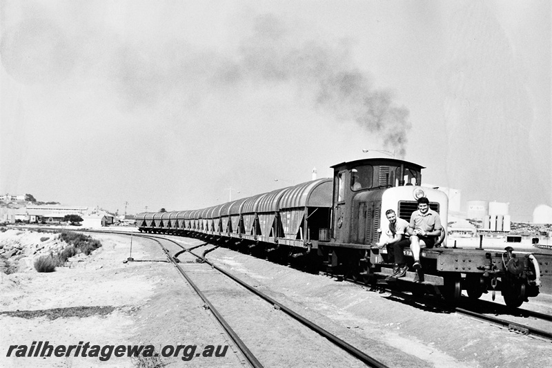 P21280
Z class 1153 on rake of wheat wagons, shunters float with two workers seated on it in front of the loco, points, point lever, Mobil oil terminal in background, Bunbury, SWR line, side and front view
