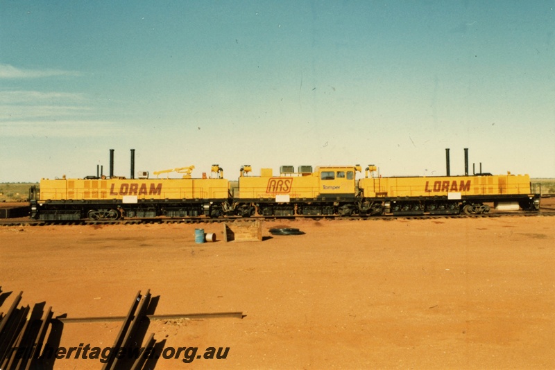 P21323
Loram Australian Rail Service rail grinder, three component units on tracks, red soil, Port Hedland, side view
