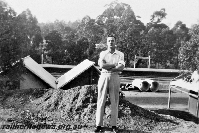 P21370
Platform, station sign, trackside buildings, drainage pipes, unknown man, Parkerville, ER line, c1932-1934
