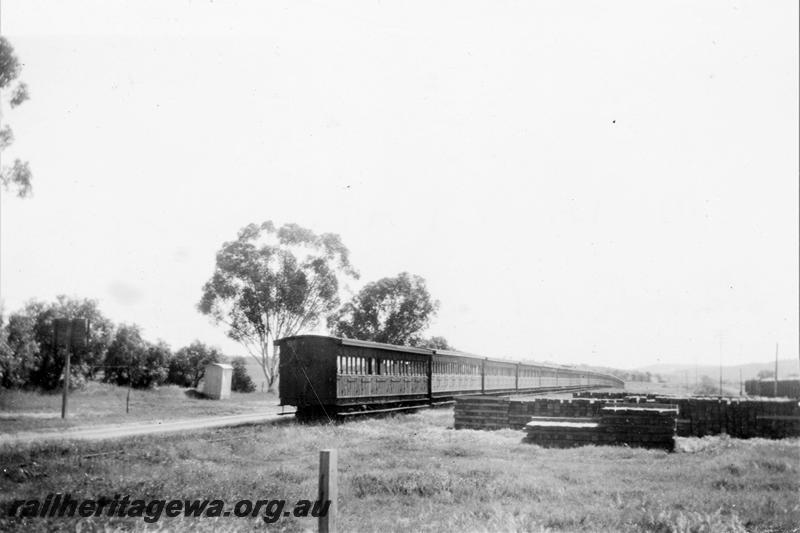 P21414
Ten AF class carriages, six AC class carriages, stowed in siding, piles of sleepers, Spencer's Brook, ER line, end and side view
