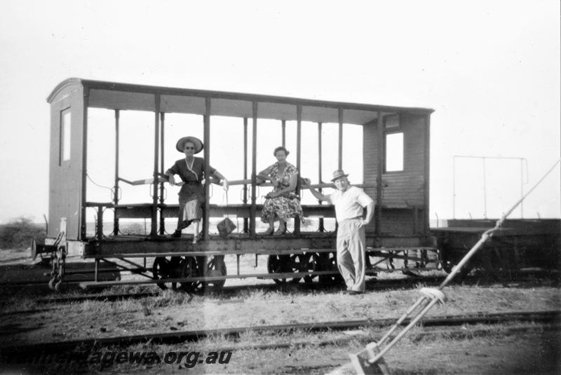 P21426
Four wheeled passenger carriage, without sides, with two ladies seated on the bench seat inside, man leaning against the carriage from track level, Derby, end and side view
