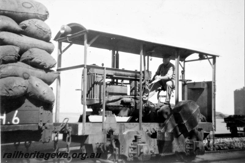 P21427
Shunting tractor, driver, wagon marked H6, piled high with full sacks, Broome, end and side view
