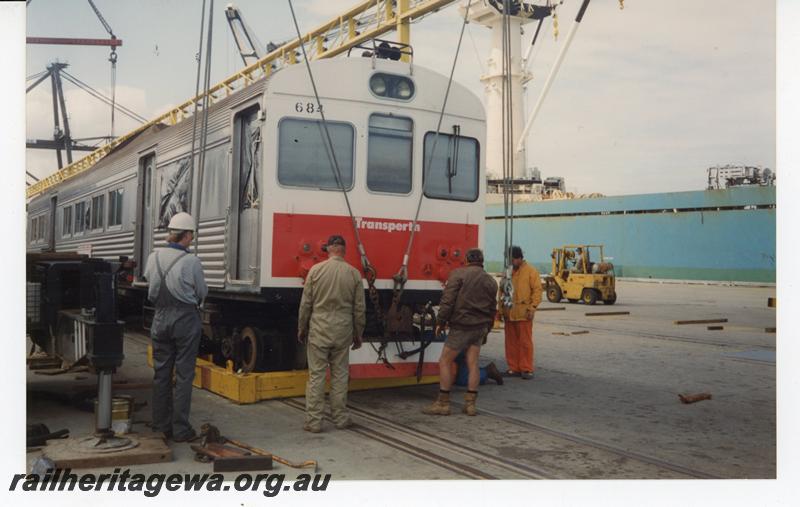 P21436
ADK class 684, bogie being lifted into cradle for shipping, crane, cables, workers, wharf, ship (part), Fremantle port, side and front view
