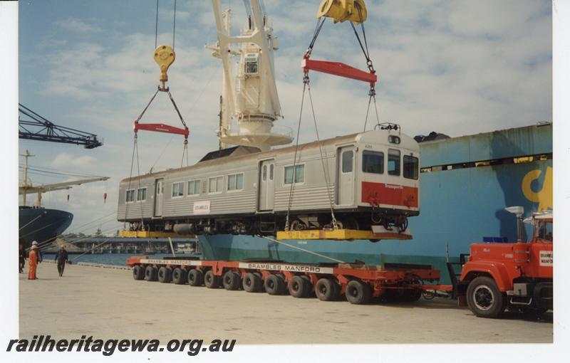 P21438
ADK class 681, being lifted off Brambles low loader for shipping to Auckland, crane, cables, workers, wharf, ships, Fremantle port,  side and front view
