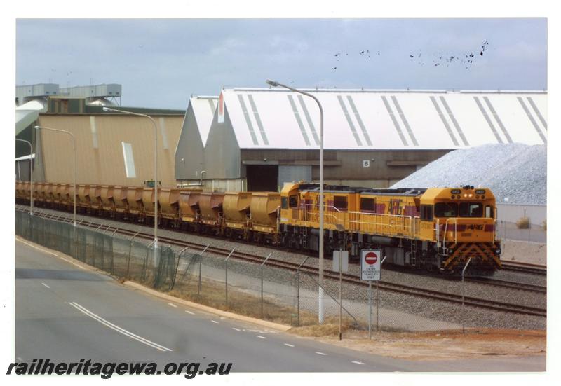 P21448
Australian Railroad Group DFZ class 2047 and another DFZ class loco, double heading iron ore train, about to depart from Geraldton port, industrial buildings, pile of gravel, Geraldton, NR line, side and front view

