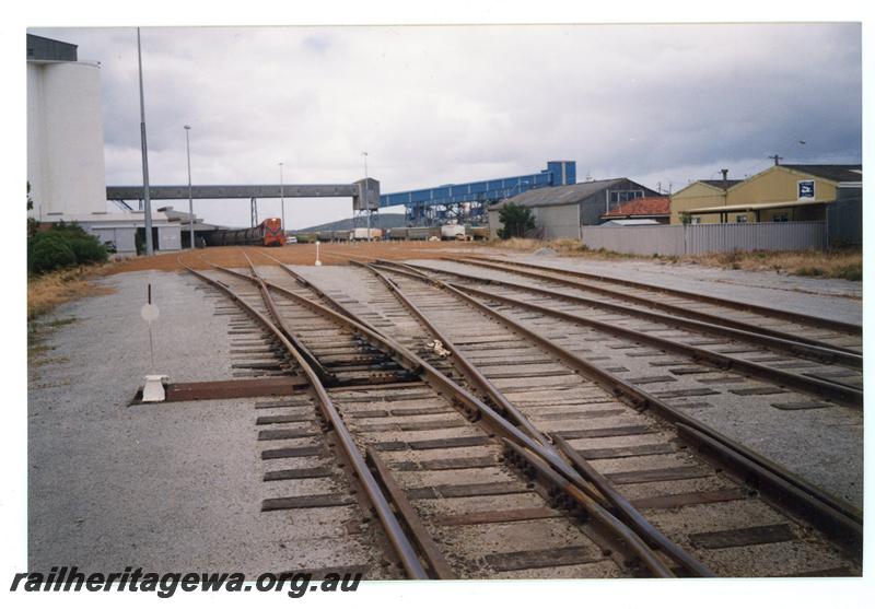 P21452
Pointwork, point lever, sidings, Westrail goods train and wagons in the distance, silos, conveyers, sheds, Albany, GSR line, track level view
