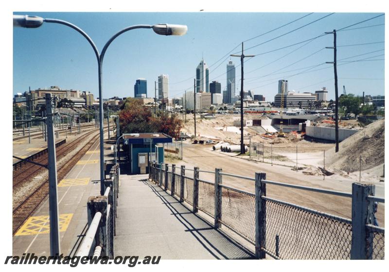 P21457
Platforms, station building, pedestrian ramp, construction site of Graham Farmer freeway, Claisebrook, ER line, view from overpass
