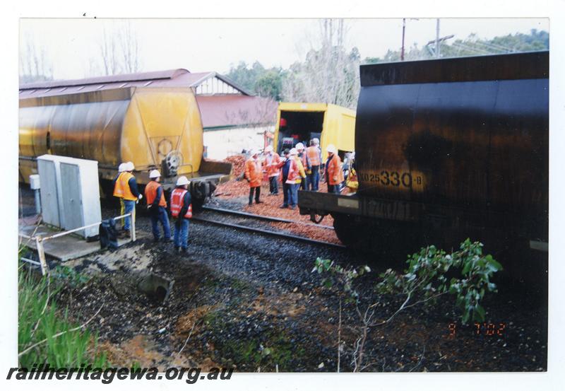 P21468
XO class 25330 woodchip wagon (part), another XO class wagon (part), crowd of workers and onlookers, culvert, truck, woodchips, Bridgetown, PP line, trackside view 
