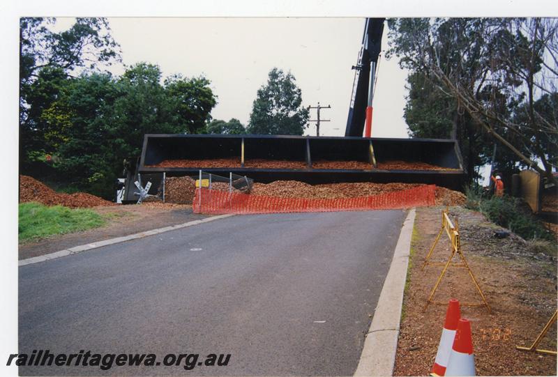 P21470
Woodchip wagon on side, woodchips spilled out on roadway, level crossing, crane, road, worker, Bridgetown, PP line, road level view
