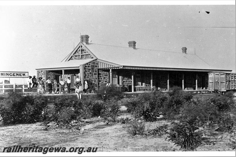 P21477
Station building, station sign, platform, livestock wagon, group of men, scrub, Mingenew, MR line, view from ground level
