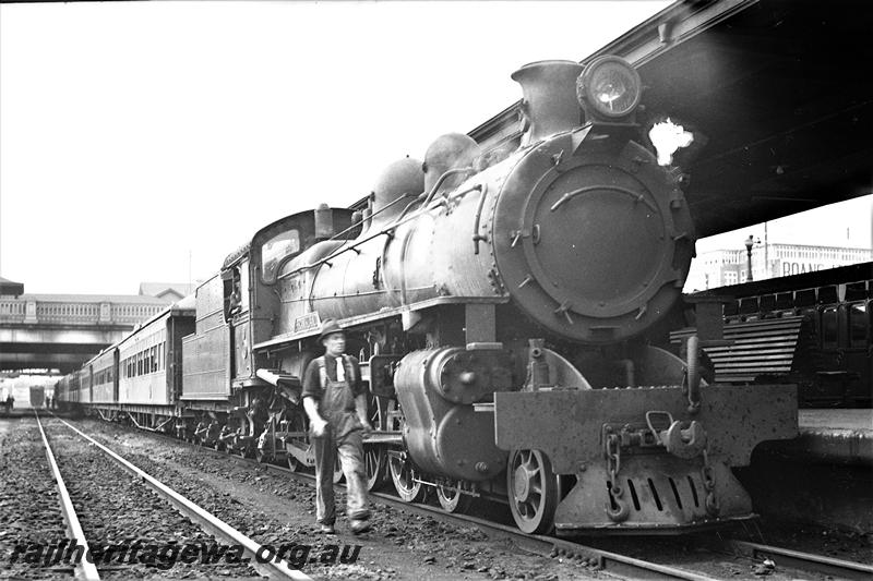 P21515
PR class loco, on passenger train, platform, canopy, overhead bridge, driver with white tie walking beside loco, tracks, Perth station, ER line, side and front view
