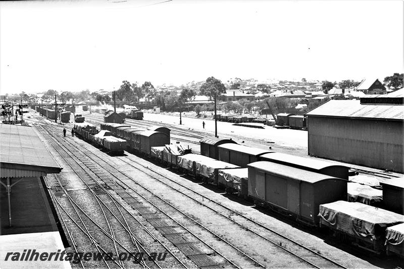 P21516
View of yard, platform, canopy, bracket signals, rakes of wagons and vans, scissors crossover, sidings, shed, houses in background, Northam, ER line, elevated view from signal box looking east
