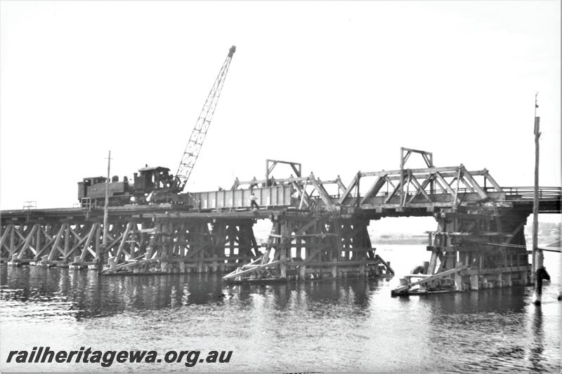 P21561
Rail bridge construction, tank loco, mobile crane, bridge trusses and supports, workers, Fremantle, ER line, view across water
