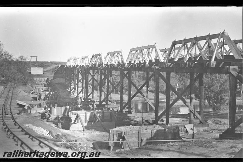 P21572
Construction of bridge foundations, construction track, wooden bridge over Greenough River, Eradu, NR line, view from bank
