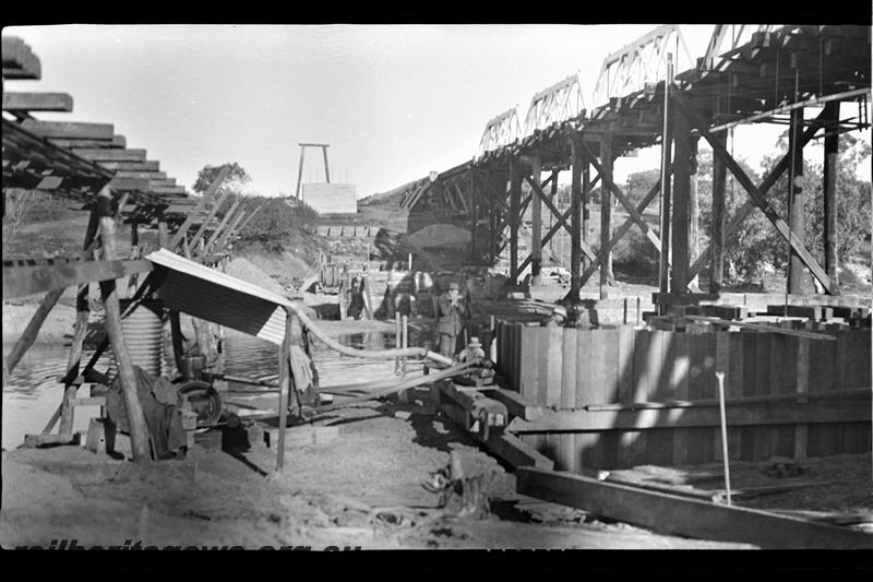 P21573
Construction of bridge foundations, construction track, workers, wooden bridge over Greenough River, Eradu, NR line, view from bank
