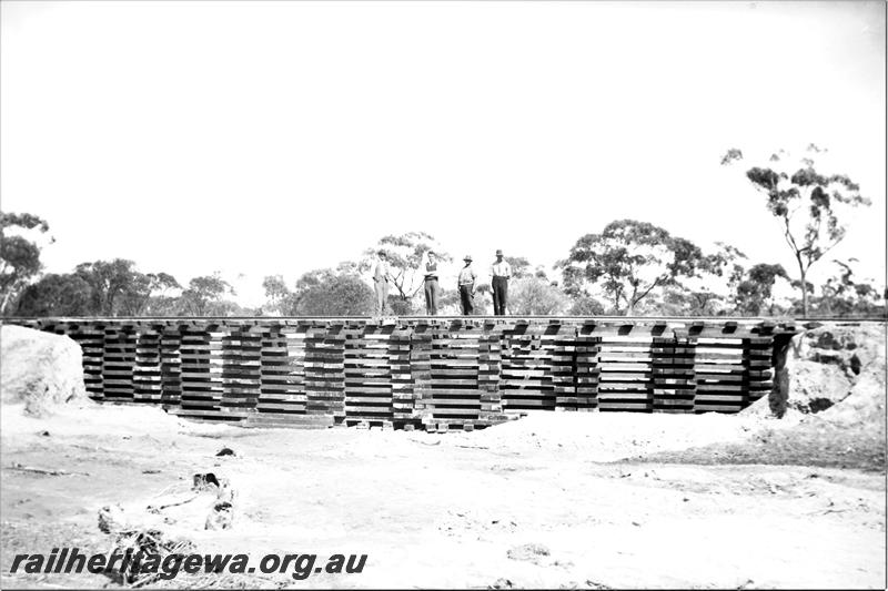 P21586
Pigstyed track at washaway, workers standing on track, view from creek bed 
