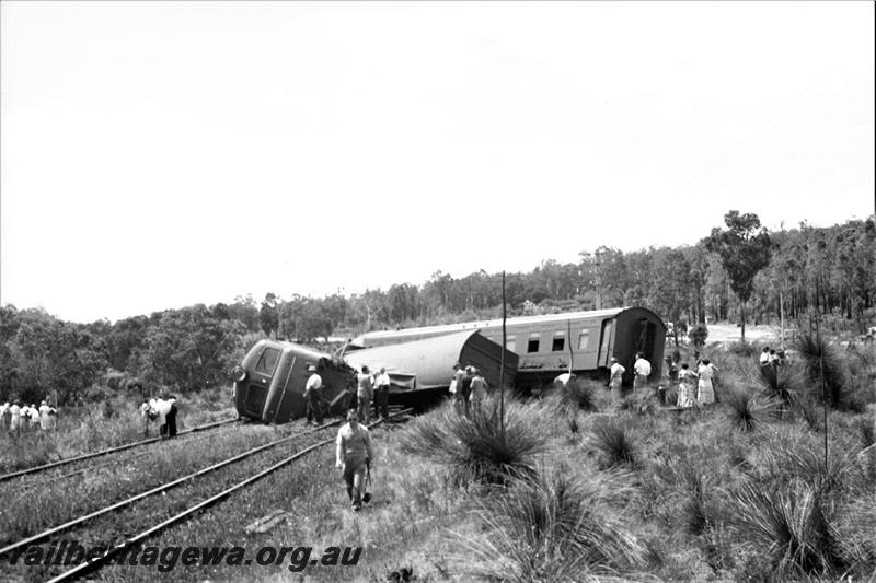 P21594
Derailment scene, X class 1005 on side, passenger carriages across tracks, crowd of onlookers,near Parkerville, ER line, view from trackside
