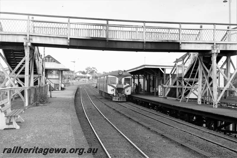 P21607
ADG class railcar at station, platforms, seats, signal box, semaphore signal, station building, overhead footway, passengers, tracks, Mount Lawley, ER line, view from platform
