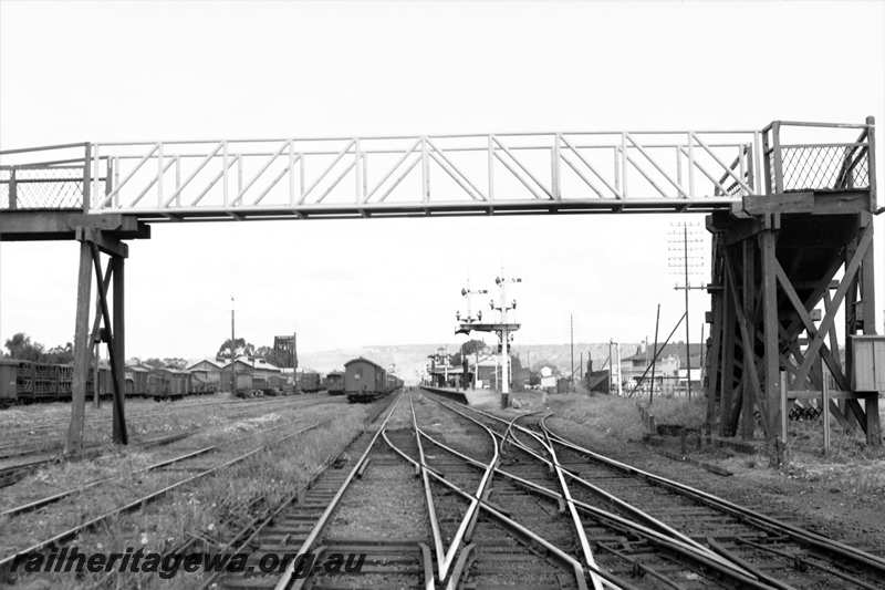 P21610
Station and yard, assorted wagons, overhead footway, tracks, points, scissors crossover, bracket signals, platform, station building, water tower, hotel, Northam, EGR line, view from eastern end of station looking west
