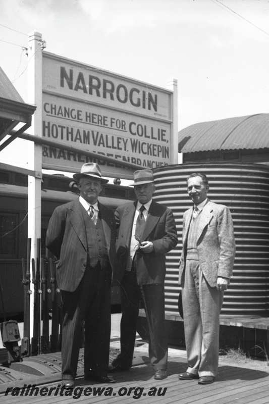 P21612
Station nameboard, platform, water tank, point levers, three men, Narrogin, GSR line, view from platform 
