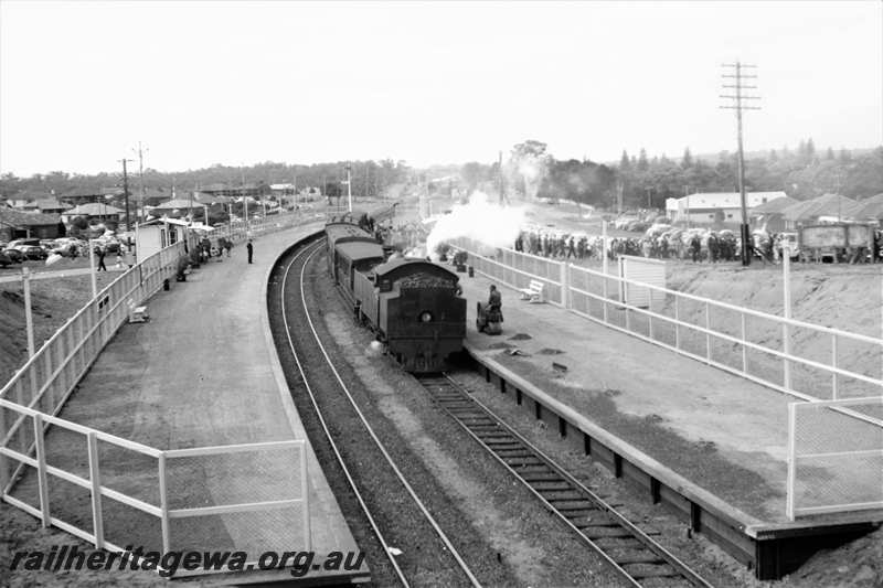 P21613
DD or DM class loco, bunker first, with plume of white smoke, on suburban passenger train, platforms, tracks, signals, passengers, Showground station, view from elevated position
