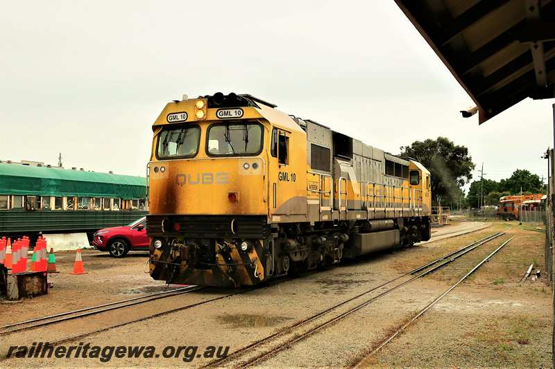 P21617
Qube loco GML class 10 in the yellow and grey livery  passing through the Railway Transport Museum en route to UGL's plant, Front and side view
