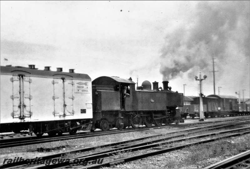 P21633
DM class 582, on down goods train, vans, wagons, signal, Perth yard, track level view
