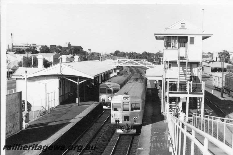 P21677
ADB class 772 in Midland bound 2 car DMU set, another DMU 2 car set City bound, platforms, station buildings, bracket signals, signal box, pedestrian ramp, vans, shed, Subiaco, ER line, view from overhead bridge
