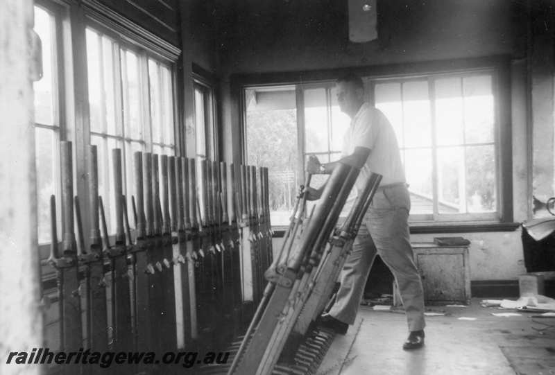 P21680
Inside of signal box no longer in use, lever frame, man pulling lever, Chidlow, ER line, interior view
