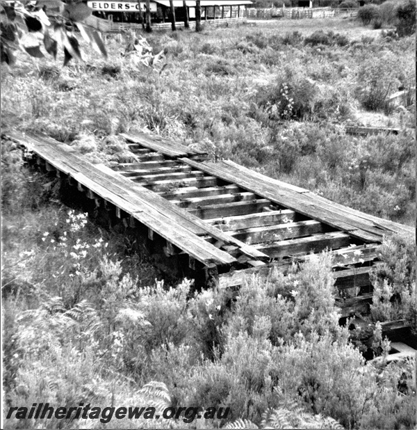 P21812
Sellers turntable, derelict, site overgrown, sleepers and deck still in place,  side and end view looking down on the deck  , Denmark,  D line. 
