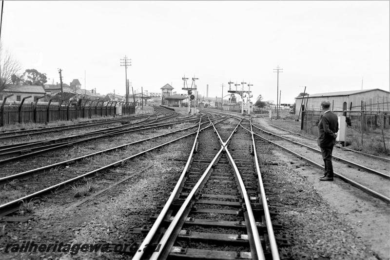 P21923
Pointwork leading to station including crossovers and slips, bracket signals, platforms, station building, overhead footbridge, signal box, onlooker, East Perth, ER line, view from track level
