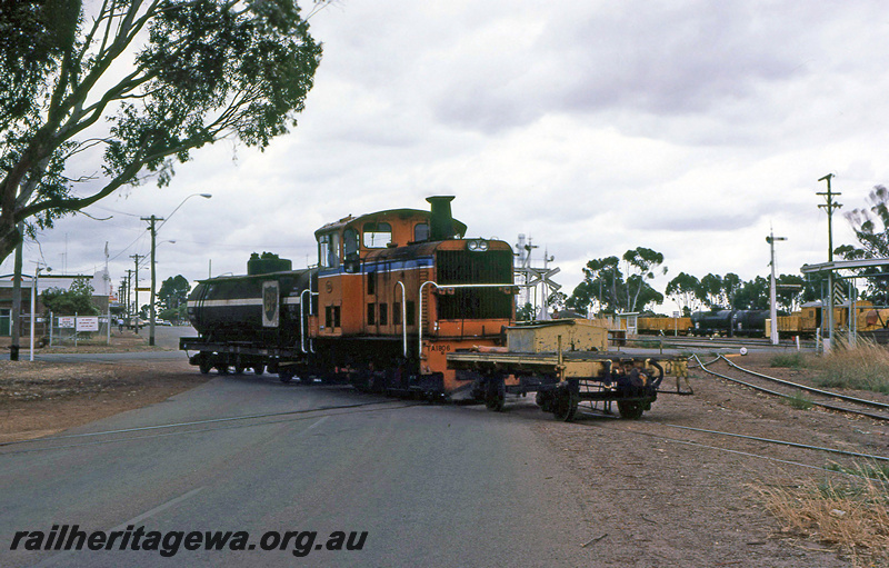P21965
TA class 1806, with short flat wagon at front and BP tanker wagon at rear, on level crossing, bracket signals, signal, wagons in yard, sidings, Katanning, GSR line, side and front view
