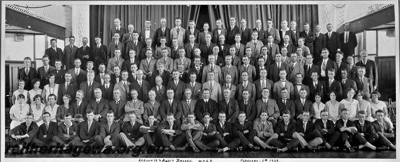 P22032
Group photo, WAGR Accounts & Audit Branch 1929. Reading from left to right. Front row: Messrs Devitt, Feeney, Tuke, O'Connor, unknown, Wormald, Diggins, Leahy, Hambleton, Reeves, Lowry, Doherty, Hogan, Flaherty, Collins, unknown, Warne, Jones and Pyne. Second row: Misses Atkinson, Davenport, Collins, unknown. Messrs Inglis, Carter (Senr), Hatton, Fowler, Hynes, McKenna, Price (Senr), Bromfield (Controller of Accounts and Audit), Shearer, Day, Hatfield, Hannah, Jeffery. Misses Dower, unknown, Simpson, Quinn and Paterson. Third row: Misses Millar, Eastmon, Williamson. Messrs unknown, Hogue, Sheridan, Simes, Taylor, Rowe, Atkinson, A. Smith, Spour, F. Lapsley, unkown, Maloney, Donohoe, Lowe, Nind, Ardagh, A. Palmer and Sundercombe. Fourth row: Messrs Randell, Maltman, S.J. Day, Howe, Wilkins, Rutherford, Keane, Tennant, Doherty, Bage, Owens, Grigg, Gibbons, Gloster, Campain, Hall, Snowball, J.R. Smith, Olliver, Puttick, Williams and Gorn. Fifth row: Messrs Fawcett, Phillips, E. Lapsley, Low, Rae, G.W. Birch, Varley, Brown, Power, Riley, Paterson and Wilkinson. Sixth row: Messrs Norton, J.C. Palmer, Webb, R.E. Wright, Ames, Langsford, Cornish, Magennis (jnr), Hamley, Donovan, Gidney, Dixon, Stokes, Cooke, Lankester, Blight anb Ridley. Back row: Messrs Frank, Venner, Anderson, Haydon, Miller, Downing, Peirce, Althorpe, C.V. Green, Huxtable, R.A. Birch, Ramsbottom, Cuffe, Scanlan, Atkins, Kelly, C.H. Atkinson and A.E. Green. Absent, on A/C, Annual leave, etc: Messrs H. Jones, H. Palmer, R. Parry, Miss Harper, Messrs LeCornu, Carter (jnr), Adam, Hammond, A.G. Wright, A.R. Yews, Louth, Johansen, Grieve, Lewis, Price (jnr), Huntley, Magennis (Snr), Pearcy, Balmer, and Salkilld. 
