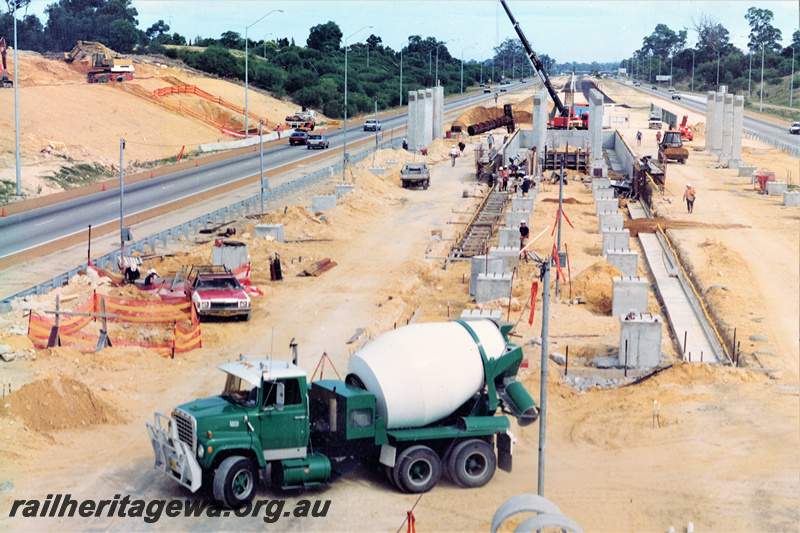 P22036
Construction of Whitfords interchange station, foundations, retaining walls, bridge supports, cement mixer, crane, excavator, workers, Mitchell freeway on both sides of construction site, Joondalup line, view from elevated position, NSR line.
