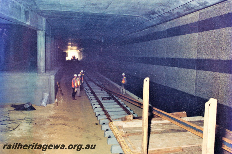 P22037
Track laying, underground between Joondalup station and Currambine station, concrete sleepers, wagon carrying rail, supports, workers, Joondalup line, view inside tunnel, NSR Line

