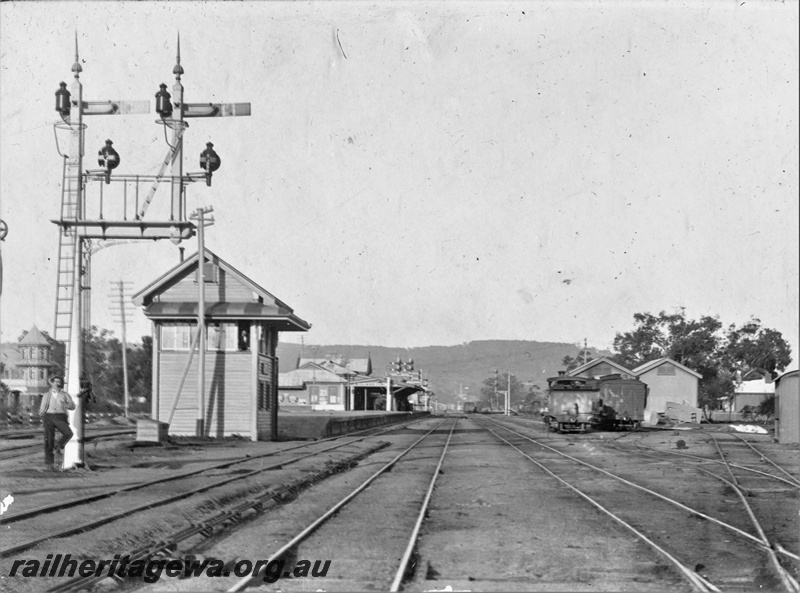 P22161
Station building, platform, canopy, bracket signals, signal box, goods shed, yard, tracks, bystander, Midland Junction, ER line, c1900
