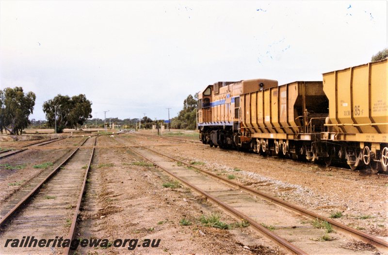 P22195
A class 1513, on ballast train comprising XK class hoppers, yard, sidings, Wyalkatchem, GM line, view from trackside looking towards front of train
