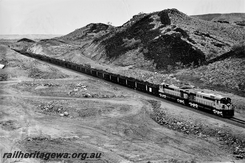 P22199
Cliffs Robe River diesels numbered 1711 and 1713, double heading first iron ore train on Pannawonica to Cape Lambert Railway, 23 miles from Cape Lambert, Pilbara, side and front view from elevated position
