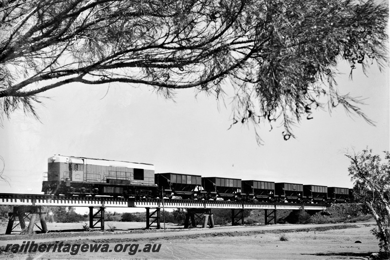 P22202
Goldsworthy Mining A class diesel loco, similar to the WAGR K class loco on train of empty ore wagons, crossing Turner River bridge, Pilbara, front and side view from dry river bed
