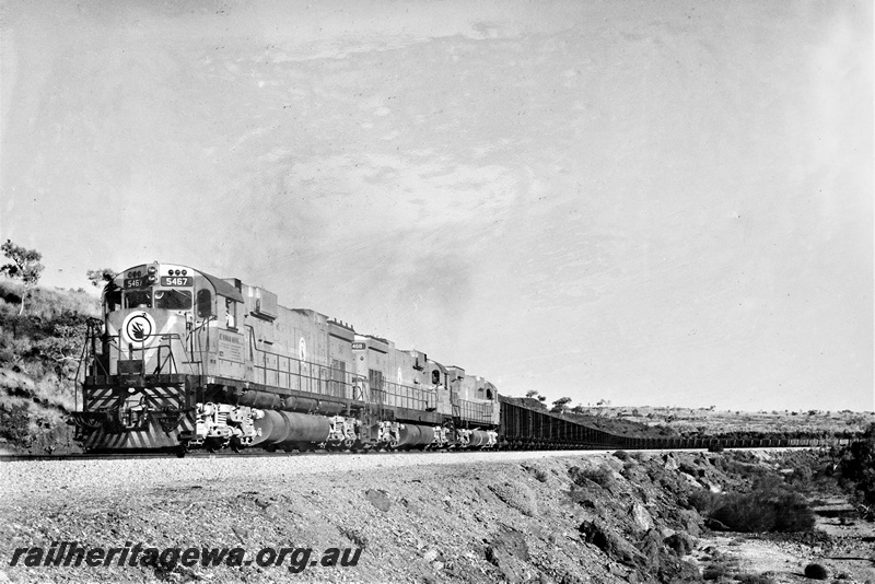P22214
Mount Newman Mining diesels numbered 5467, 5468 and another, triple heading iron ore train, bound for Port Hedland, departing Newman, front and side view

